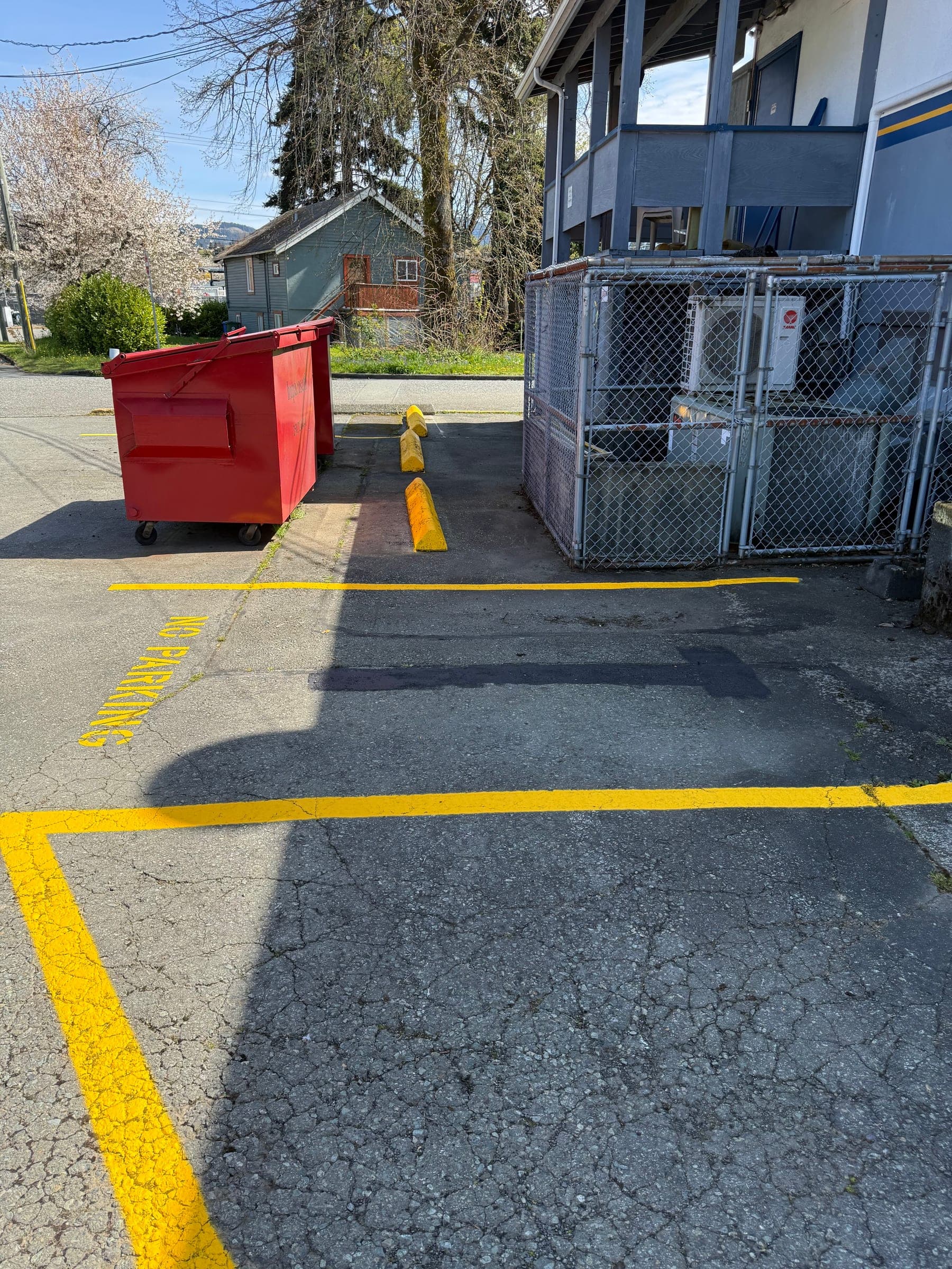 After photo of a freshly painted no parking area and yellow curbside lines.
