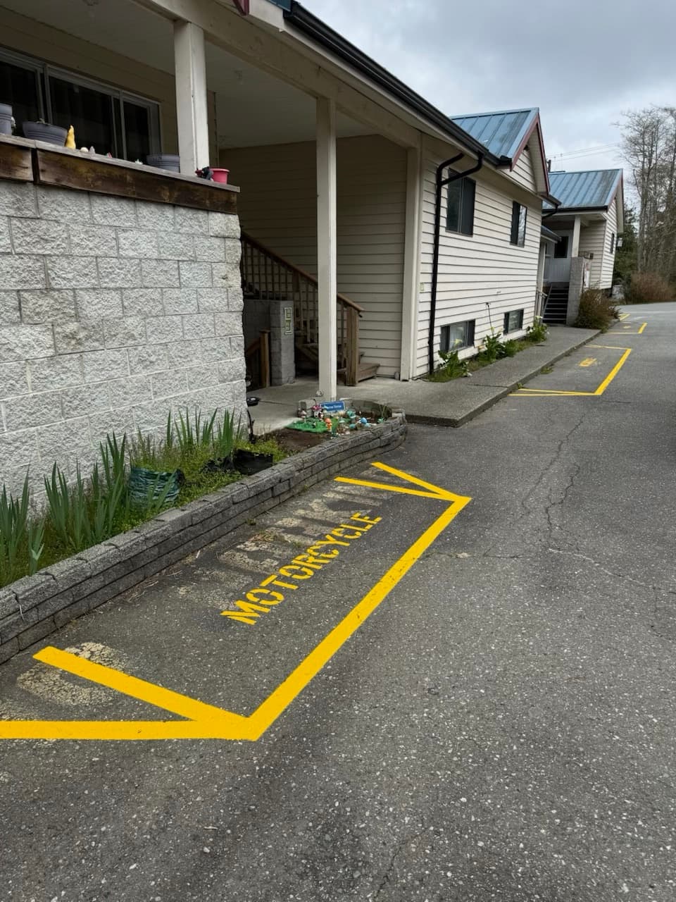 After photo of freshly painted yellow no parking lines beside a residential building.